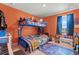 Orange walled bedroom showcasing a bunk bed, window, and an array of decorative items at 348 Hidden Cove Dr., Little River, SC 29566