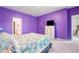Purple bedroom showcasing a bed, dresser, TV, and doorway to the en-suite bathroom at 348 Hidden Cove Dr., Little River, SC 29566