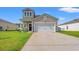 Charming two-story home featuring a two-car garage, lush lawn, and covered porch at 348 Hidden Cove Dr., Little River, SC 29566