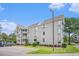 Exterior corner unit shows multi-story building with multiple balconies, landscaping, and parking at 351 Lake Arrowhead Rd. # 24-396, Myrtle Beach, SC 29572