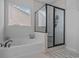 Bright bathroom with a garden tub, separate glass shower, and a window for natural light at 3620 Diamond Stars Way, Little River, SC 29566
