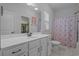 Well-lit bathroom with white vanity, large mirror, and walk-in closet access at 3620 Diamond Stars Way, Little River, SC 29566