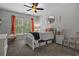 Cozy bedroom featuring a brick accent wall, a stylish ceiling fan, and natural light from the window at 3620 Diamond Stars Way, Little River, SC 29566