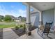 Cozy rocking chair on a covered front porch with stone supports and a view of the neighborhood at 3620 Diamond Stars Way, Little River, SC 29566