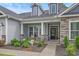 Inviting front porch with decorative columns, stone accents, and a cozy seating area with landscaped garden at 3620 Diamond Stars Way, Little River, SC 29566