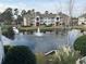 Scenic view of a pond with fountain, surrounded by condo buildings and lush greenery at 3761 Citation Way # 531, Myrtle Beach, SC 29577