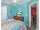 Bright bedroom with blue walls, a TV, and a glimpse into another bedroom at 404 1St Ave. N # H, North Myrtle Beach, SC 29582
