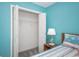 Bedroom featuring an organized closet, blue walls, and a comfortable bed at 404 1St Ave. N # H, North Myrtle Beach, SC 29582