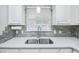 The kitchen features white cabinets, quartz countertops, and an undermount sink at 404 1St Ave. N # H, North Myrtle Beach, SC 29582