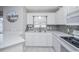 Well-lit kitchen with white cabinets, stainless steel appliances and modern backsplash at 404 1St Ave. N # H, North Myrtle Beach, SC 29582