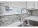 Kitchen sink with modern faucet, quartz countertops, white cabinets, and stone backsplash at 404 1St Ave. N # H, North Myrtle Beach, SC 29582