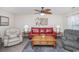 Bright living room with a ceiling fan, wood floors, and comfortable sofa and armchairs at 404 1St Ave. N # H, North Myrtle Beach, SC 29582