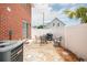 Paver patio with grill, outdoor furniture, and a well-maintained air conditioning unit in this backyard at 404 1St Ave. N # H, North Myrtle Beach, SC 29582