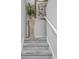View of carpeted staircase with decorative floral arrangement on a column stand at 404 1St Ave. N # H, North Myrtle Beach, SC 29582