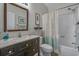 A well-lit bathroom featuring dark wood cabinets, a framed mirror, and a shower with a curtain at 4450 Turtle Ln. # 2-A, Little River, SC 29566