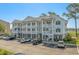Inviting three-story condo building with white siding, brick accents, and spacious balconies and well-maintained landscaping at 4450 Turtle Ln. # 2-A, Little River, SC 29566
