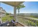 A screened porch with chairs and a table, offering views of the water and surrounding greenery at 4450 Turtle Ln. # 2-A, Little River, SC 29566