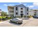 Inviting condo complex featuring manicured landscaping, classic architecture, and convenient parking spaces at 4520 Coquina Harbour Dr. # F-3, Little River, SC 29566