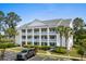 Beautiful condo building with stately columns, balconies, lush landscaping, and parking at 4940 Windsor Green Way # 301, Myrtle Beach, SC 29579