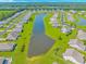 Aerial view of a residential community featuring a central pond and manicured green spaces at 5 Coffee Mill Creek Ln., Carolina Shores, NC 28467