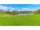 Expansive backyard with lush green grass, serene pond views, and charming single-story homes nearby at 5 Coffee Mill Creek Ln., Carolina Shores, NC 28467