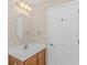 Bright bathroom featuring a vanity with an oval mirror and a white paneled door at 5 Coffee Mill Creek Ln., Carolina Shores, NC 28467