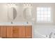 Bathroom featuring double sinks, wood cabinet, and a luxurious soaking tub with tile surround at 5 Coffee Mill Creek Ln., Carolina Shores, NC 28467