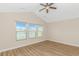 Bedroom with natural light from a window overlooking a lake, ceiling fan, and wood floors at 5 Coffee Mill Creek Ln., Carolina Shores, NC 28467