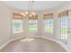 Cozy dining area with tile flooring, a chandelier, and windows overlooking a peaceful pond at 5 Coffee Mill Creek Ln., Carolina Shores, NC 28467