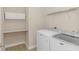 Functional laundry room with a shelf and modern washer and dryer units at 5 Coffee Mill Creek Ln., Carolina Shores, NC 28467