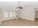 Bright living room featuring wood floors, ceiling fan, and multiple windows with a view at 5 Coffee Mill Creek Ln., Carolina Shores, NC 28467