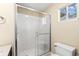 A bright bathroom featuring a glass door shower, toilet, and window at 500 Myrtle Greens Dr. # D, Conway, SC 29526