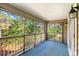 Enjoy nature views from this screened porch with its blue carpeted floor and wooden railings at 500 Myrtle Greens Dr. # D, Conway, SC 29526