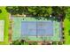 Aerial view of a fenced tennis court surrounded by green trees and landscaping on a sunny day at 500 Myrtle Greens Dr. # D, Conway, SC 29526