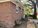 Exterior view of the red brick house with a bench and HVAC system at 505 1St Ave. S, North Myrtle Beach, SC 29582