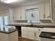 Well-lit kitchen featuring white cabinets, black countertops, and modern fixtures at 505 1St Ave. S, North Myrtle Beach, SC 29582