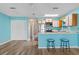 Open living and kitchen area with breakfast bar, blue walls, stainless appliances, and wood-look floors at 510 Fairwood Lakes Dr. # 19-Q, Myrtle Beach, SC 29588