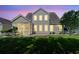 Home exterior at dusk featuring a screened-in patio and a sprawling green lawn at 5146 Fairmont Ln., Myrtle Beach, SC 29579