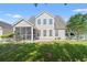 Well-maintained home exterior with a screened-in patio and a spacious green lawn at 5146 Fairmont Ln., Myrtle Beach, SC 29579