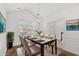 The dining room features a table set for six, wainscoting, a chandelier, and lots of light from a large window at 5146 Fairmont Ln., Myrtle Beach, SC 29579