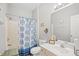 A well-lit bathroom featuring a shower with printed curtain, toilet, vanity, and neutral decor at 5406 Sweetwater Blvd. # 5406, Murrells Inlet, SC 29576