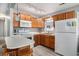 Bright kitchen features wood cabinets, white appliances, island with bar seating, and gray flooring at 6001-1833 S Kings Hwy., Myrtle Beach, SC 29575