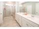 Bright bathroom with a double sink vanity, a glass enclosed shower and beige tile at 6080 Zoe Way, Myrtle Beach, SC 29588