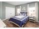 Cozy bedroom with a comfortable bed, two windows, two side tables and lamps, and a double-door closet at 6080 Zoe Way, Myrtle Beach, SC 29588