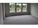 Bright bedroom with gray carpet and three large windows offering a view of the beautiful pond at 6080 Zoe Way, Myrtle Beach, SC 29588