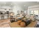 Bright living room featuring two sofas, a coffee table, and an open-concept design connecting to the kitchen and dining area at 6080 Zoe Way, Myrtle Beach, SC 29588