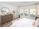 Sun-filled bedroom featuring a dresser, a round mirror, a queen size bed and an ensuite bathroom at 6080 Zoe Way, Myrtle Beach, SC 29588