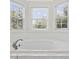 Close up of bathroom soaking tub next to bay windows with a view of greenery and blue sky at 62 Warbler St., Georgetown, SC 29440