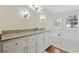 Bright bathroom with a granite countertop, white cabinets, and a soaking tub with surrounding windows at 62 Warbler St., Georgetown, SC 29440