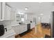Bright kitchen featuring white cabinetry, marble counters, stainless appliances, and hardwood floors at 62 Warbler St., Georgetown, SC 29440